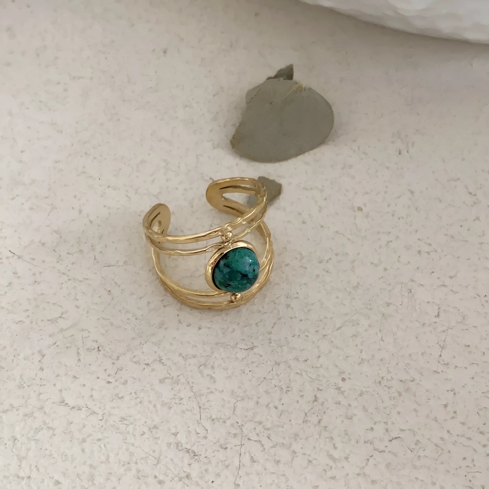 Geometric open ring with a green natural stone set on a titanium steel electroplated band.