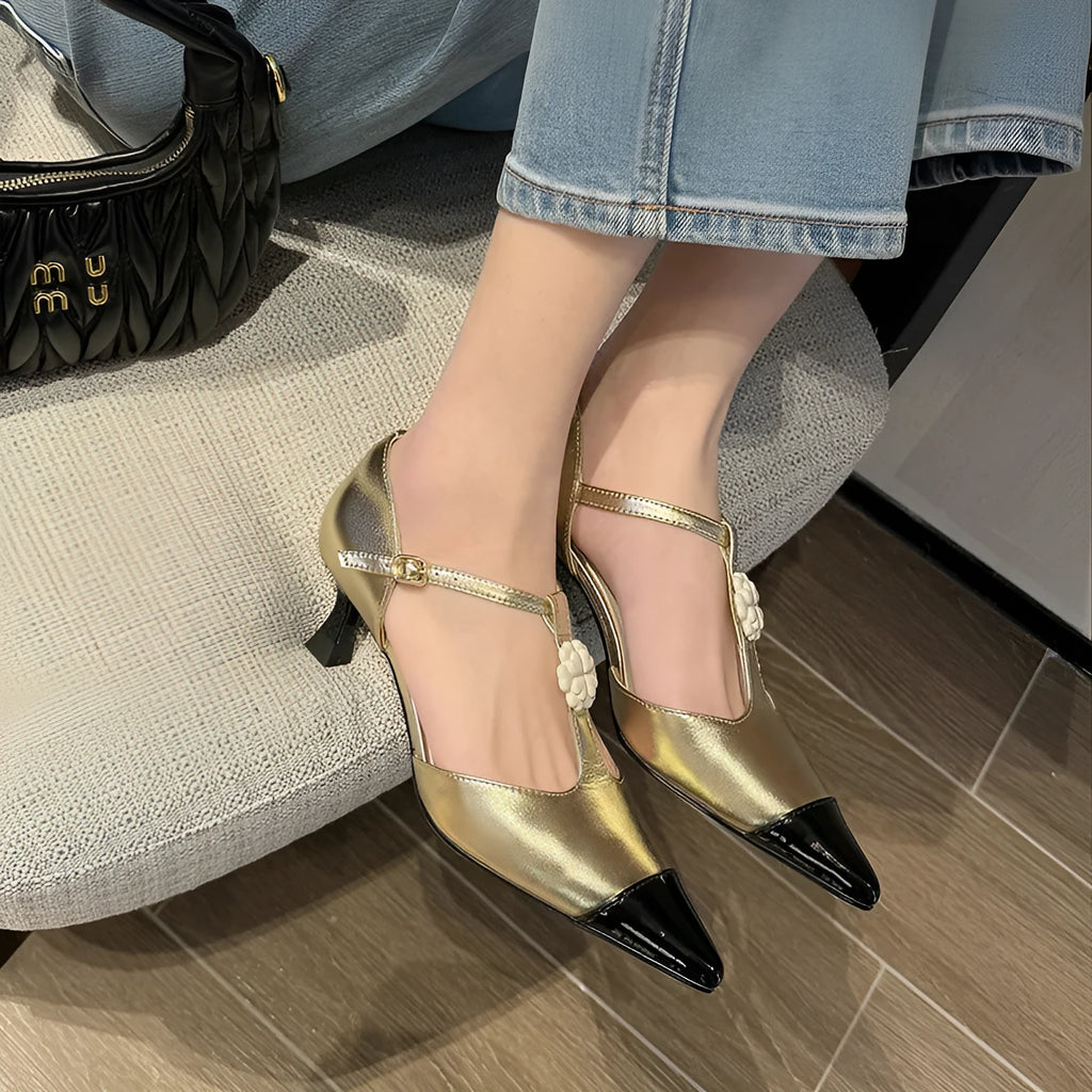 Women's gold stiletto heel with pointed toe, flower buckle, and shallow mouth cut on a sheepskin upper.