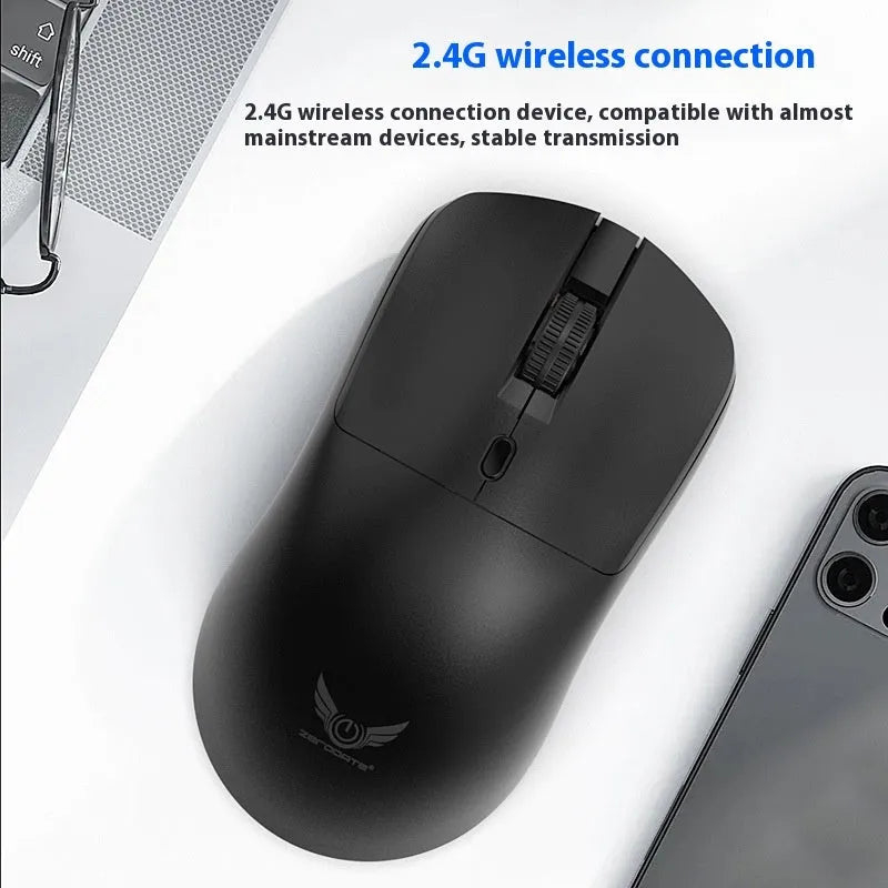 Black wireless mouse with a three-gear audio button on a desk next to a laptop.