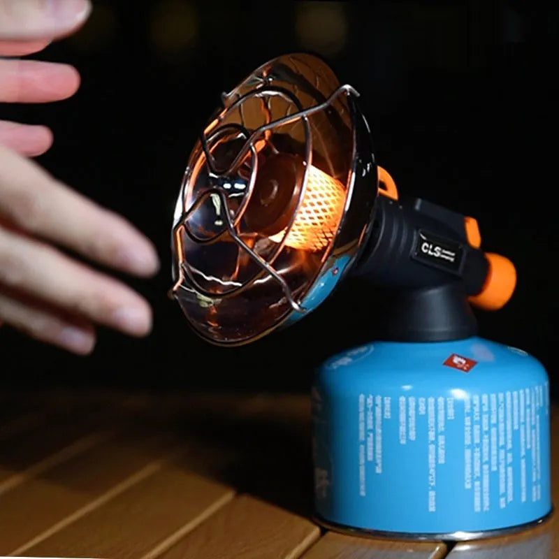 Black and orange portable outdoor camping heater stove with automatic ignition on a table.