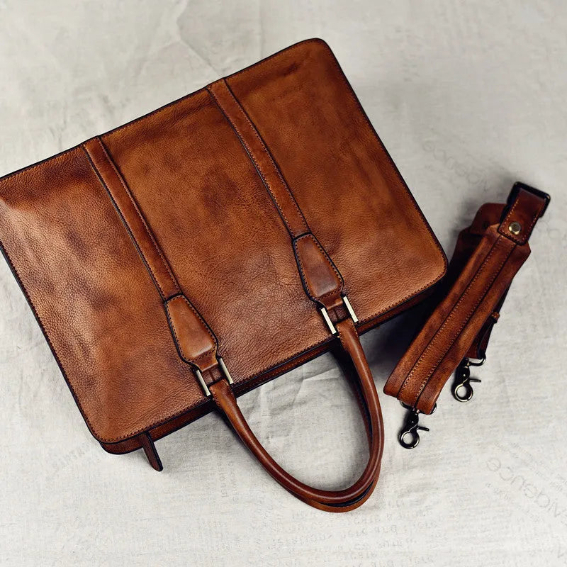 Men's brown leather retro style horizontal handbag with zipper, shown next to a 14-inch laptop for scale.