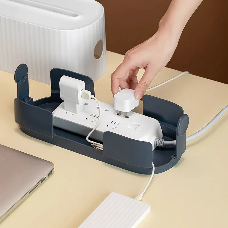 Blue and white plastic cable management box for power strips with lid open showing phone slot and cable holes