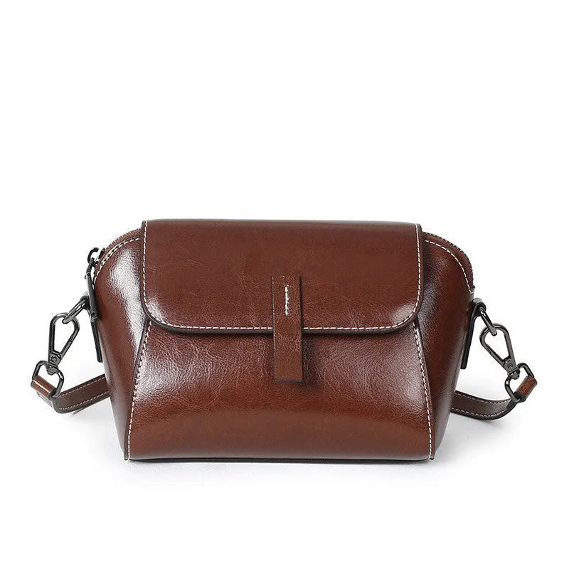 Women's brown oil-wax cowhide leather shell-shaped messenger bag with crossbody strap and visible sewing details
