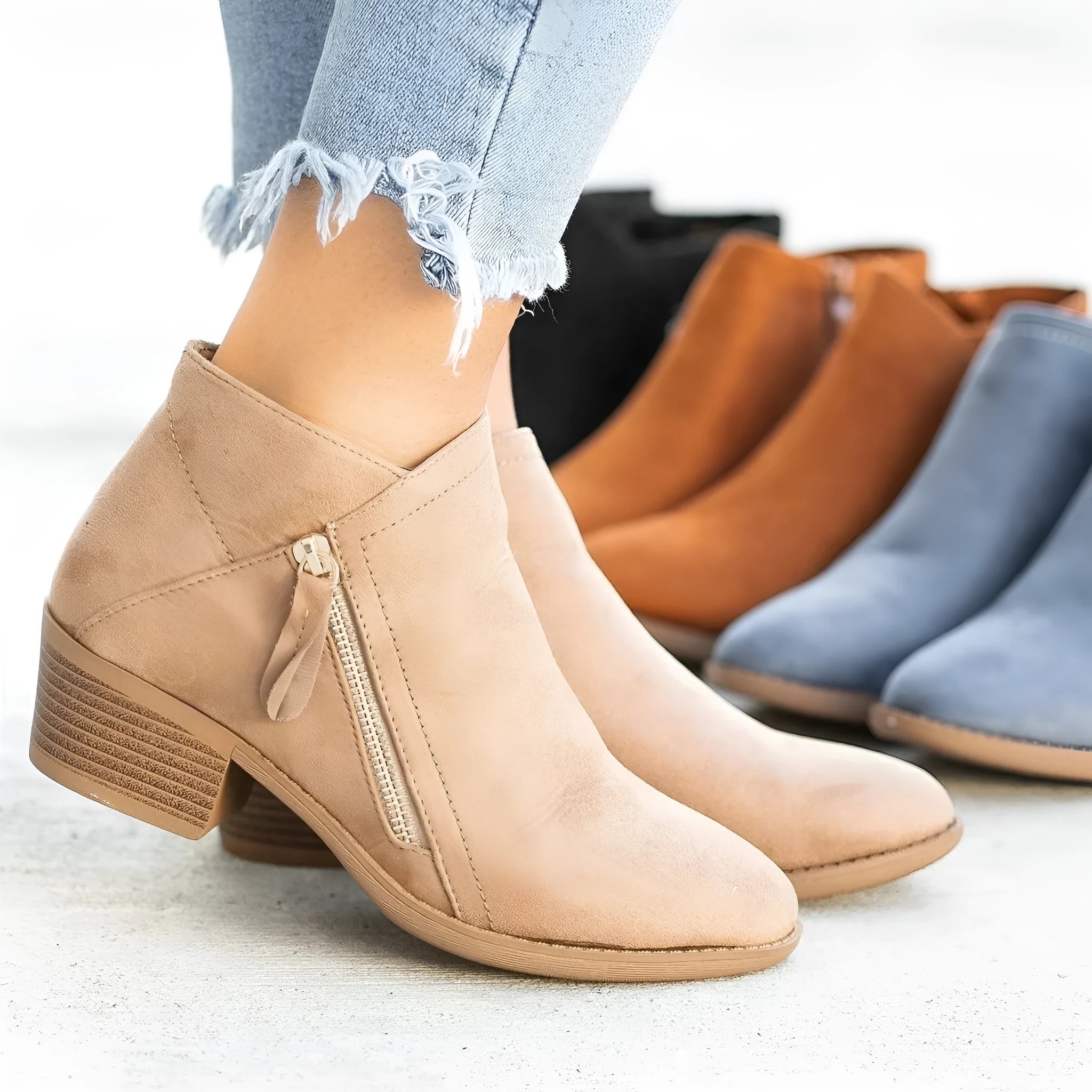 Women's blue suede ankle boots with side zip and chunky heel on wooden floor