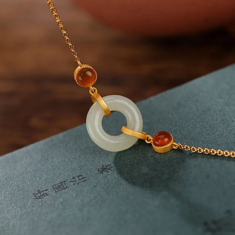 Gold-coloured women's bracelet with inlaid green Hetian jade stone and an adjustable peace buckle clasp.