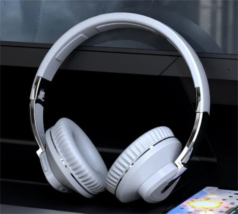 Black wireless over-ear headset with AUX cable and TF card slot, showing soft ear cups and control buttons.