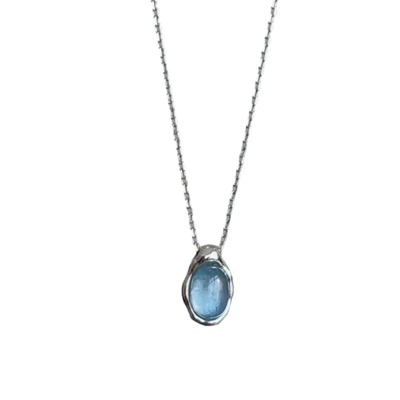 Geometric navy blue water drop pendant on an adjustable copper cross necklace for women.