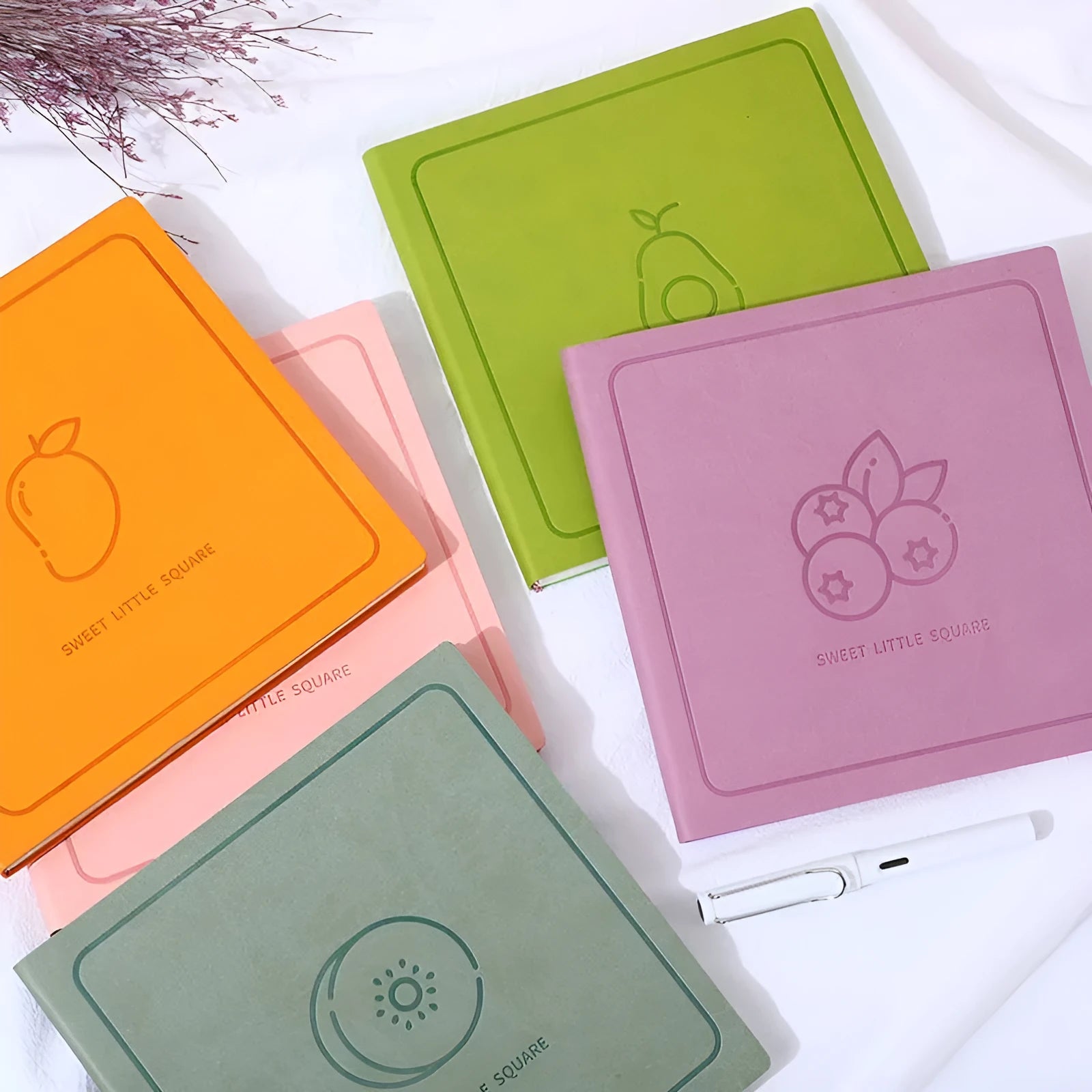 Square faux leather notebook in peach pink, avocado green, or grey green with blank, lined, or grid pages.