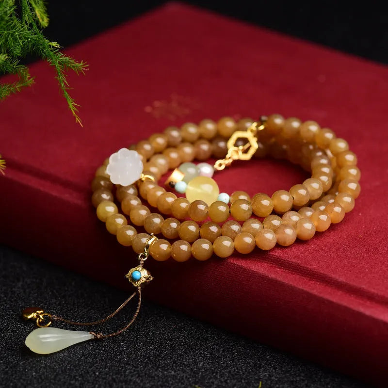 Women's jade bracelet with 6mm round beads in clear water green featuring leaf accents