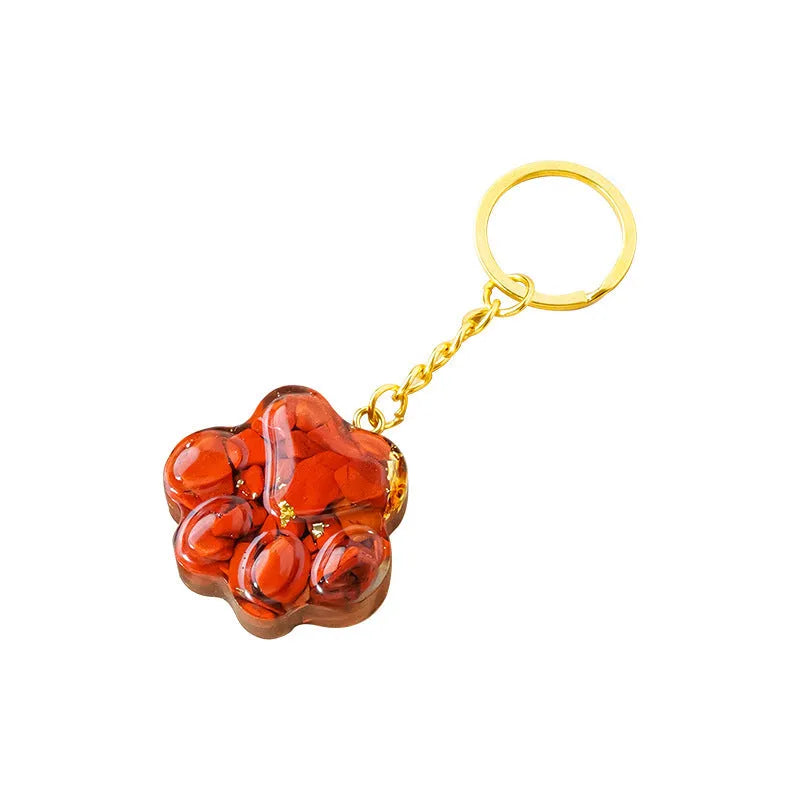 Small natural crystal cat's paw shaped pendant on a keychain ring, shown in various crystal colour options.