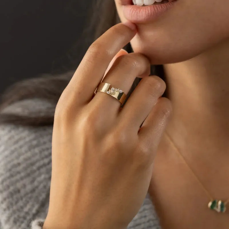 Women's gold electroplated zircon ring on finger showing brilliant stones and metallic finish