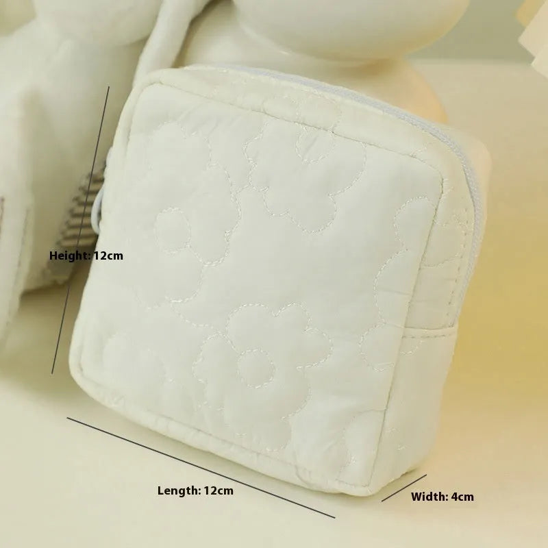 Quilted silk cosmetic storage bag in candy colours showing pink, yellow, blue, white, and green options