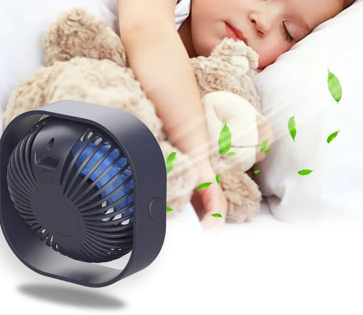 Pink USB desk fan with 360-degree rotating head on a white desk.
