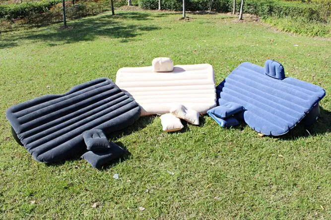 Universal inflatable car bed with flocked surface, shown with two pillows inside a vehicle.