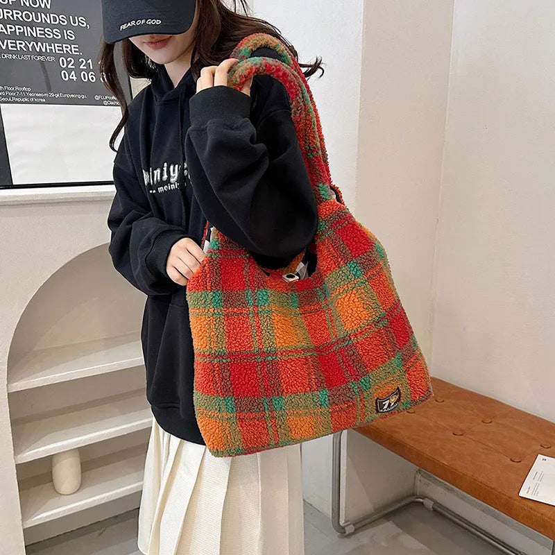 Women's plaid crossbody tote bag in soft plush fabric showing horizontal square shape and strapless shoulder strap