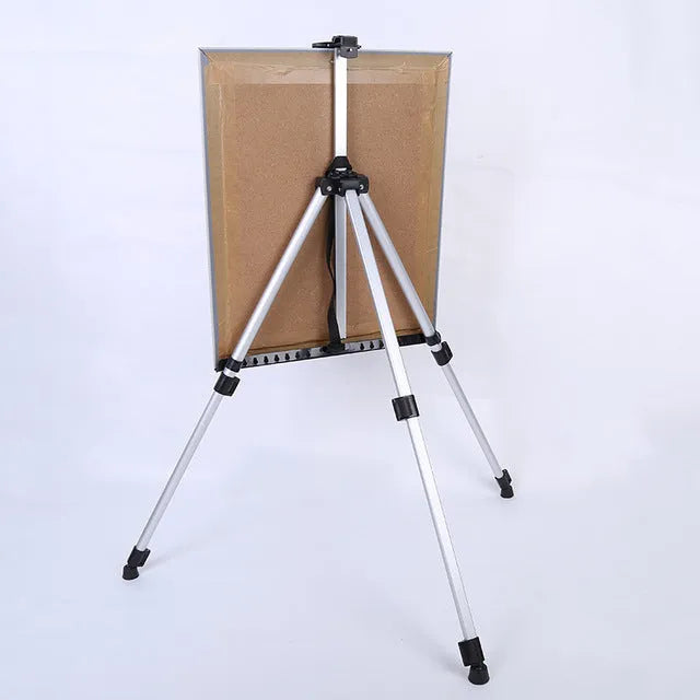 Silver aluminium alloy adjustable easel with metal tray in collapsed position on a tabletop
