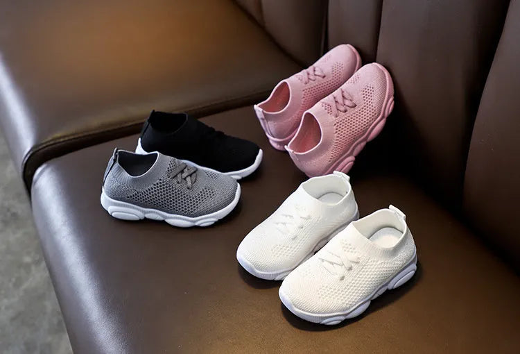 Children's lazy slip-on shoes in white, black, pink, or grey with fabric upper and rubber sole.
