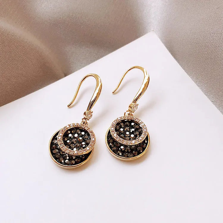Black retro-style geometric alloy earrings with a round piece, shown from the side.