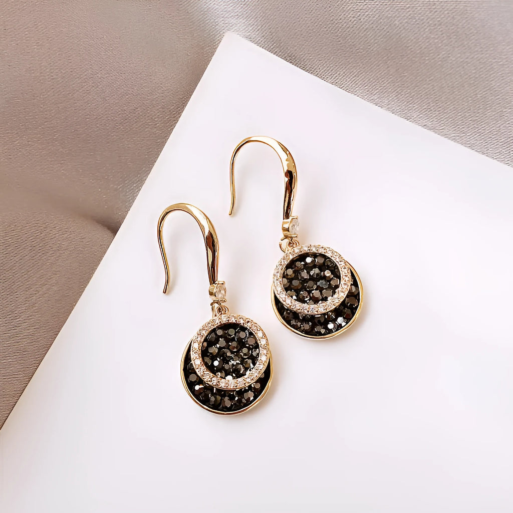 Black retro-style geometric alloy earrings with a round piece, shown from the side.