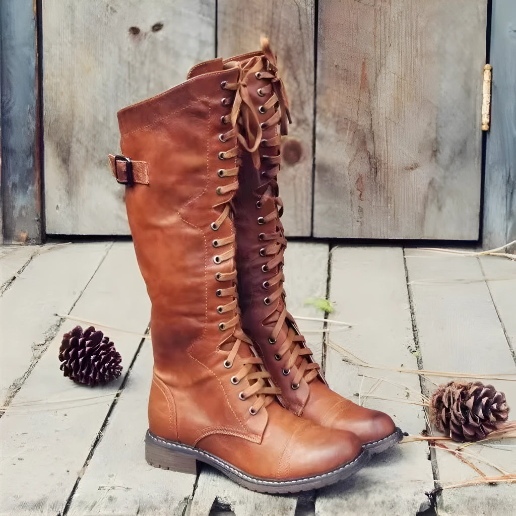 Women's black high-leg boots with a round toe and a low chunky rubber heel on a white background.