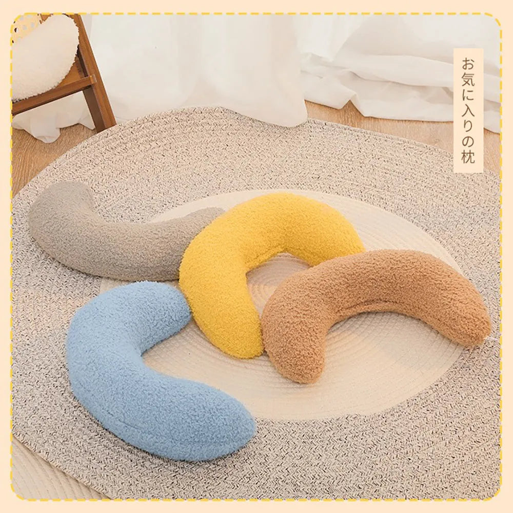 Blue U-shaped cat pillow with an adjustable fabric collar resting on a grey blanket.