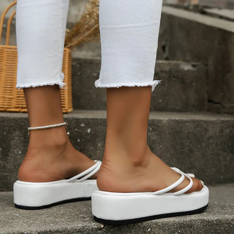 Pair of thick-soled flip-flops with herringbone patterned PU straps in a choice of colours on a white background
