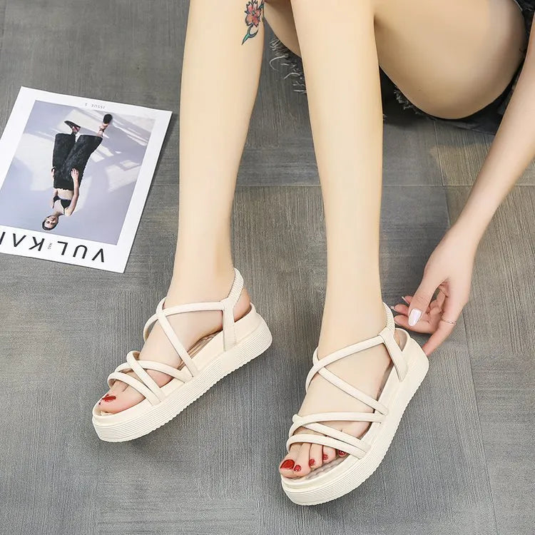 Women's black and beige Roman-style platform sandals with round toe and slip-on design.