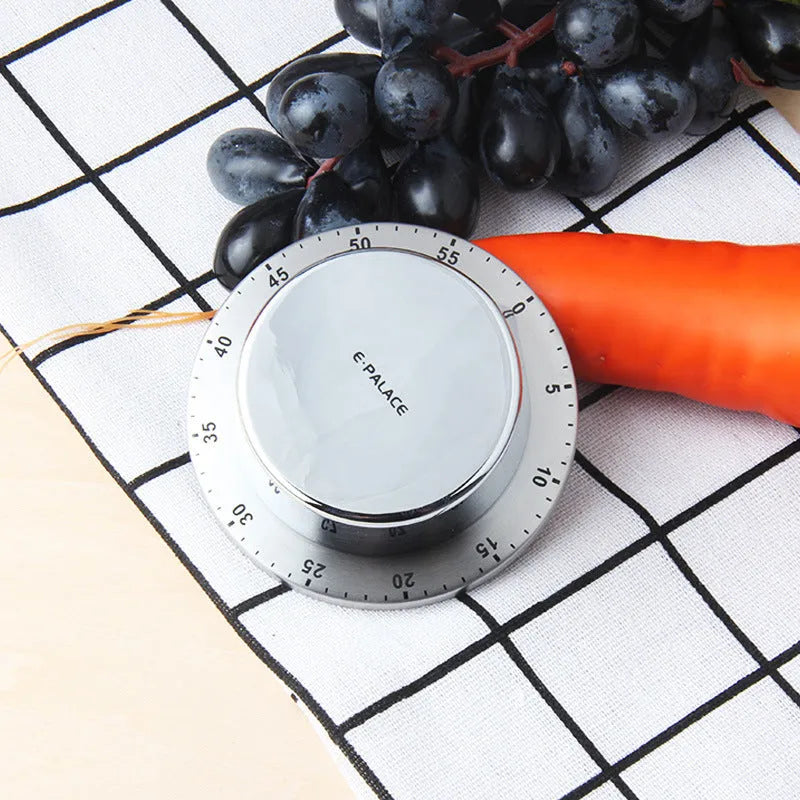 Green kitchen stainless steel mechanical timer with 60-minute dial on metal surface
