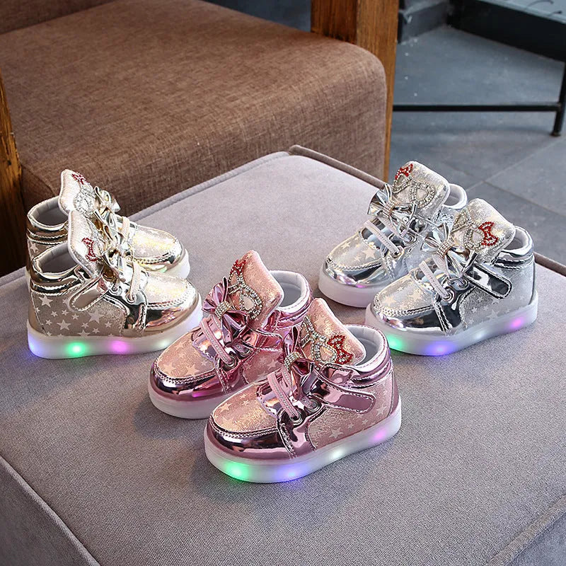 Golden children's LED sneakers with a light-up magic button on the heel
