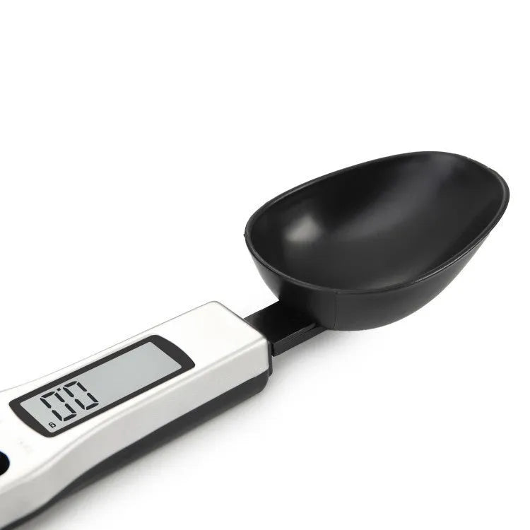 Smart digital kitchen measuring spoon with LCD display showing weight measurement.