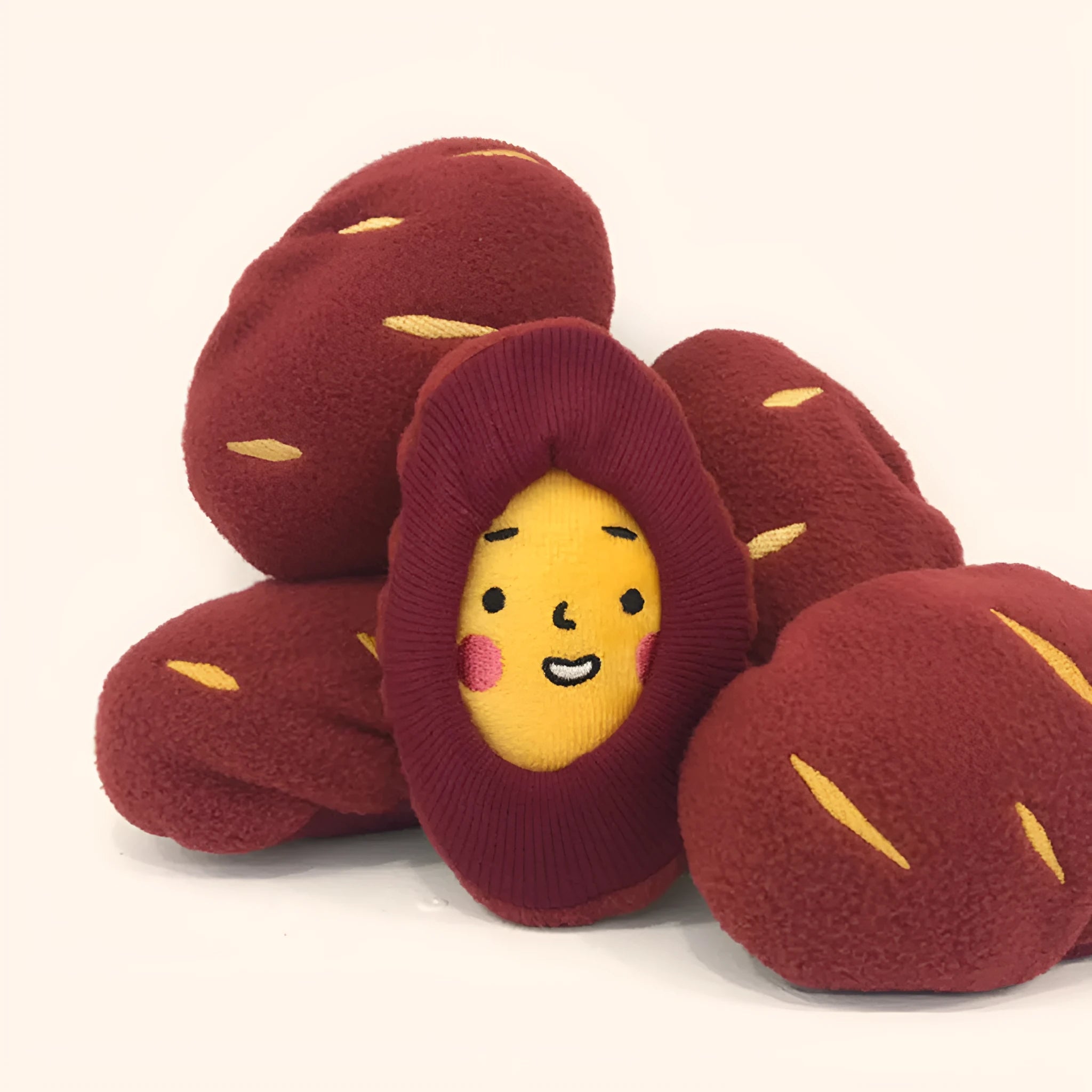 Red sweet potato pet toy with a peel-off layer and hidden treat pocket for dogs and cats.