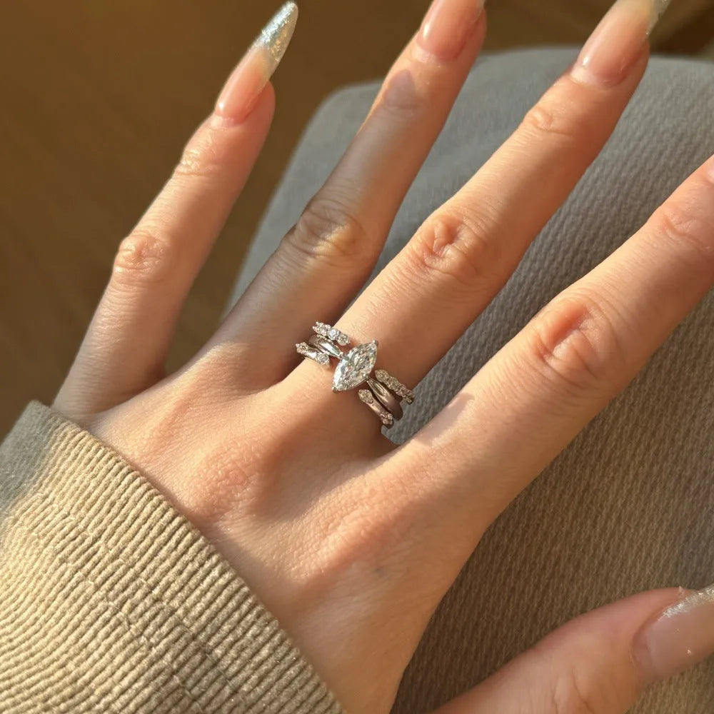 Sterling silver open ring with irregular wave design and adjustable opening on female hand