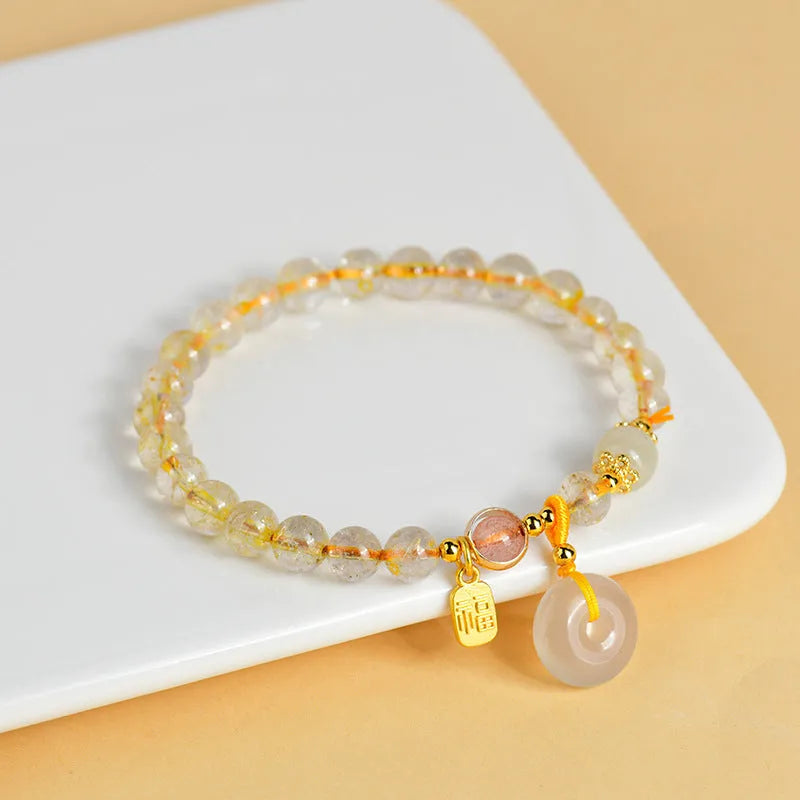 Gold rutilated quartz crystal bracelet with safety buckle and geometric blessing card pendant