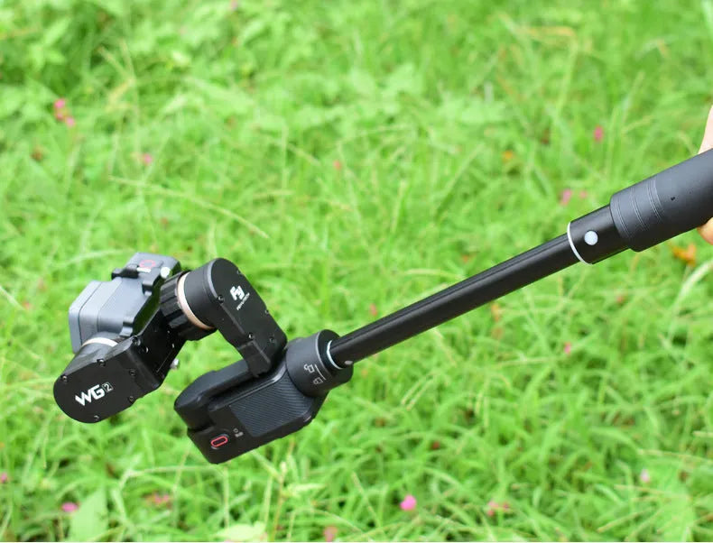 Black retractable aluminium selfie stick extended to 1.2m with a smartphone attached and a Bluetooth remote.