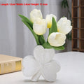 White porcelain clover-shaped ceramic vase on a desk, shown in light green colour.