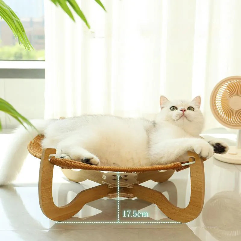 Brown woven rattan raised cot bed for cats and small dogs on a wooden floor