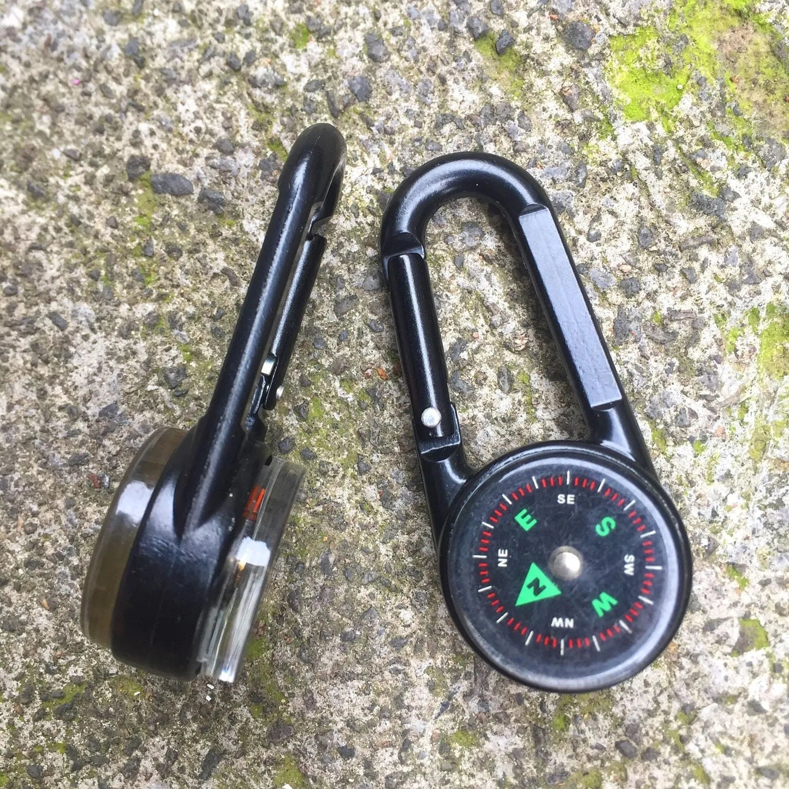 Black zinc alloy camping carabiner with built-in compass and thermometer, showing double-sided button and 65mm size.