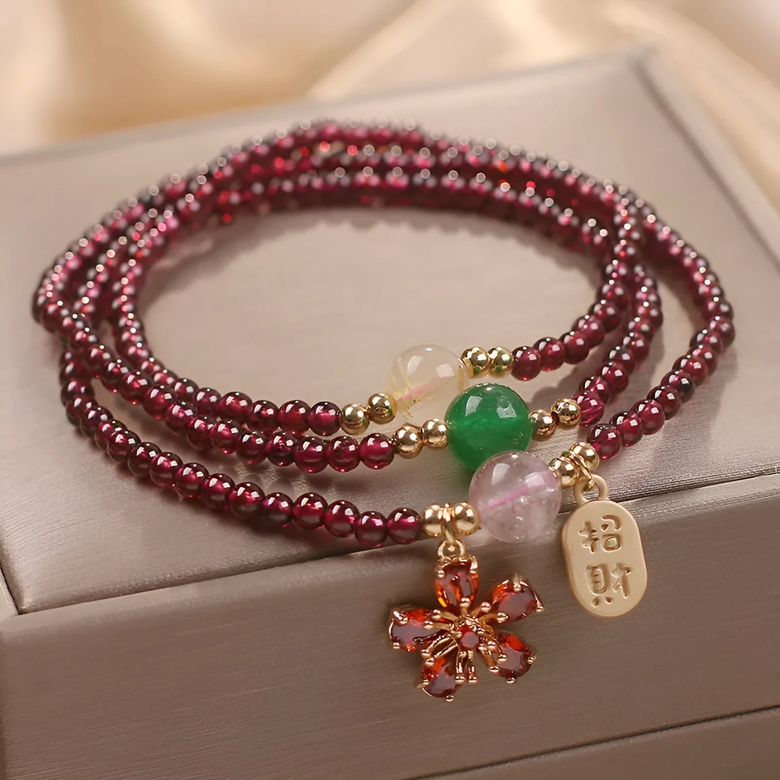Women's natural crystal bracelet in pomegranate red cherry blossom colour with sequin details on strap.