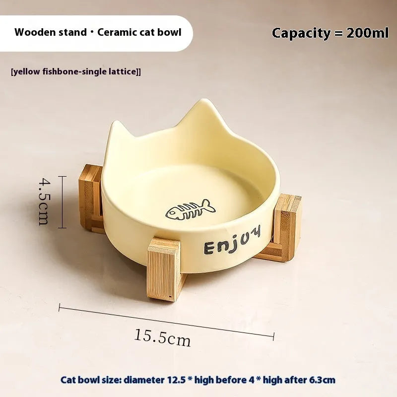 Porcelain cat bowl with cat ear handles in a wooden anti-tumble frame, showing paw print design.