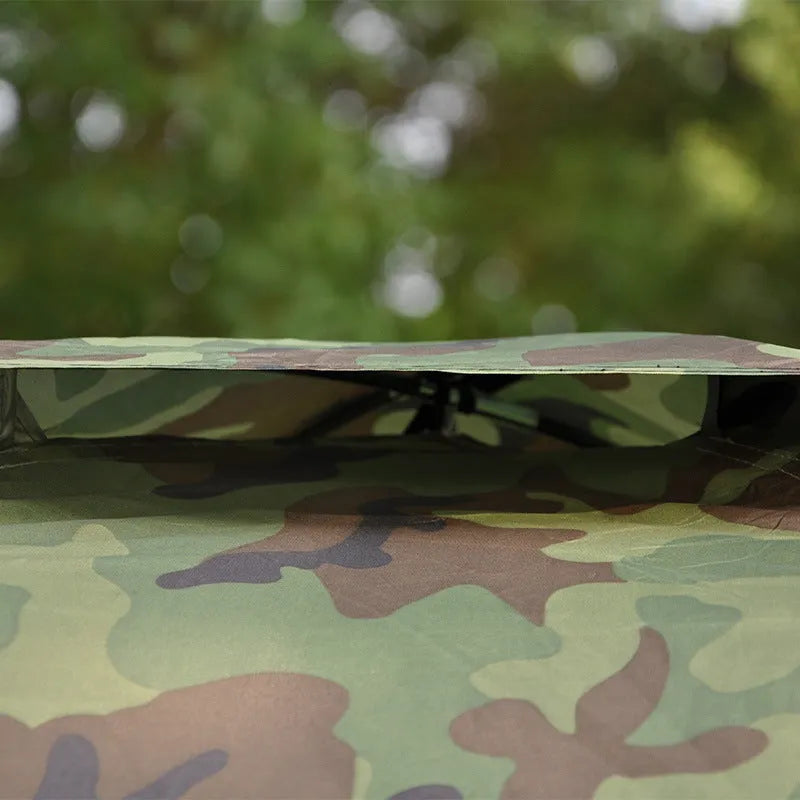 Green and brown camouflage pattern two-person camping tent with mesh windows, shown pitched outdoors.