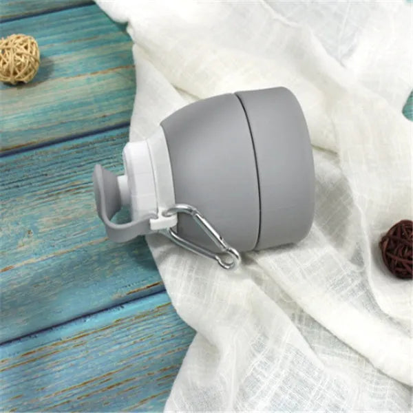 Blue silicone folding water bottle shown extended and collapsed, with 580ml capacity mark.