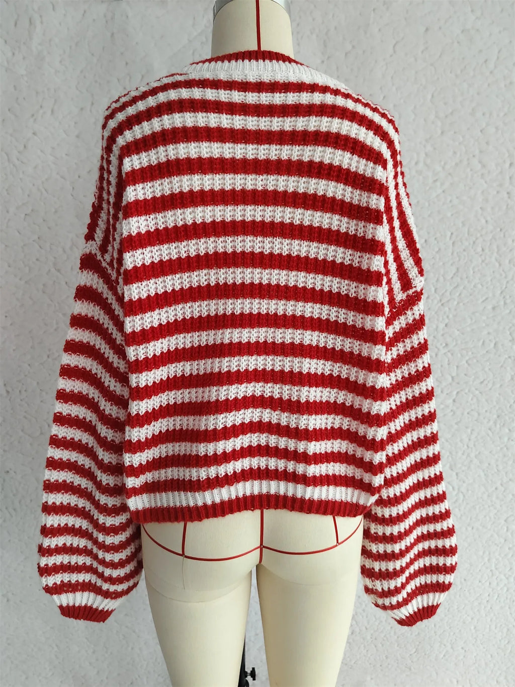 A woman's loose-fitting striped pullover sweater with a round neck and long sleeves in a khaki colour.