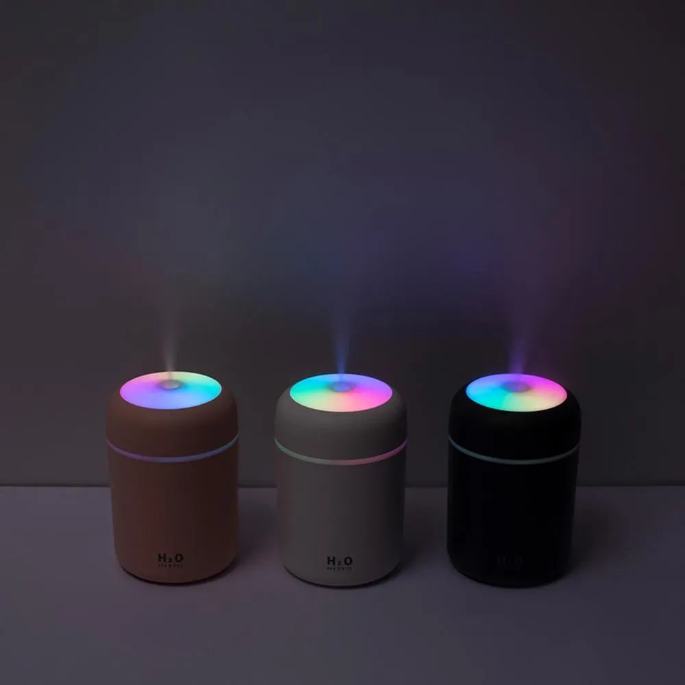 Pink, white, and navy blue USB-powered mini desktop humidifier with water tank and mist spray.