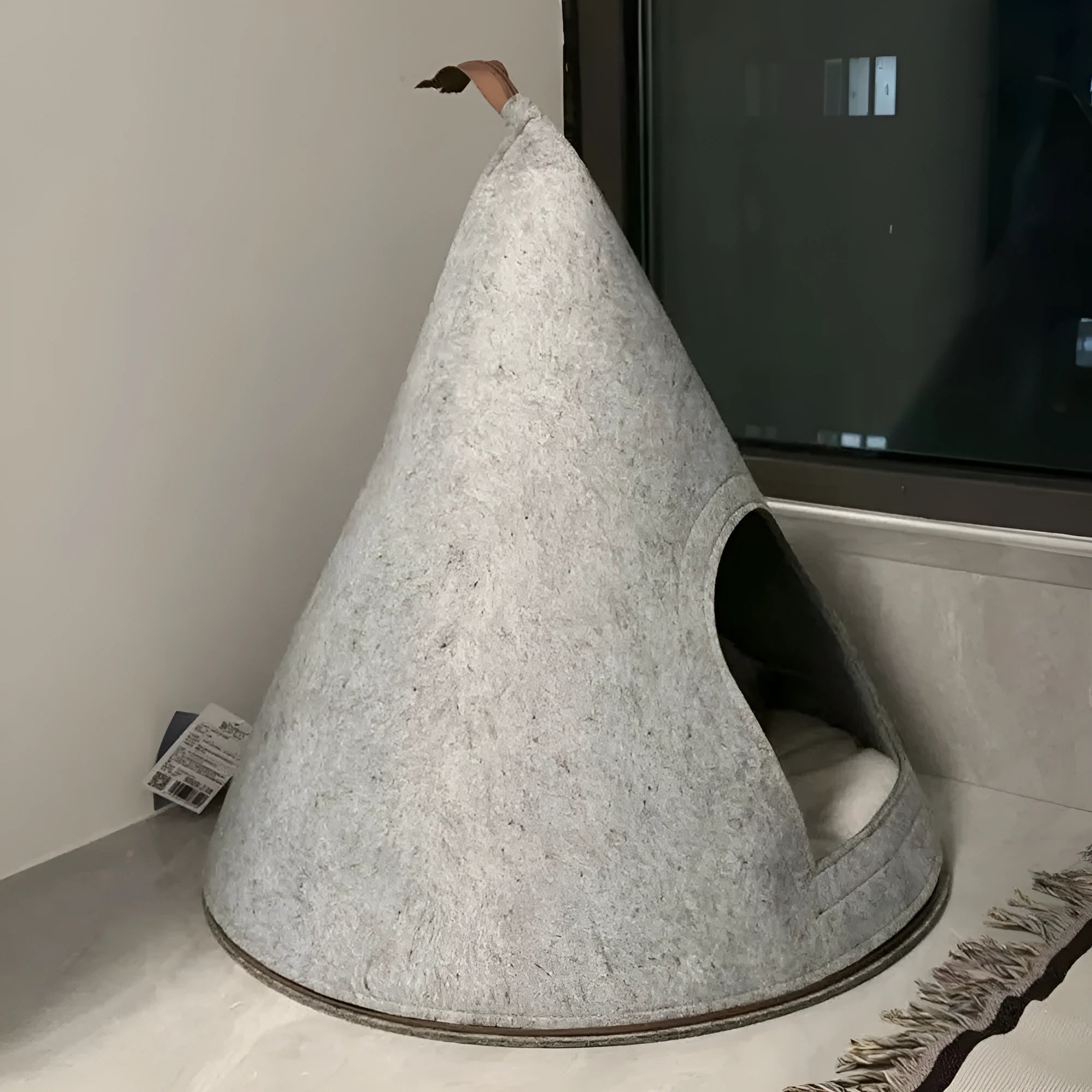 Grey cone-shaped felt cat house with tent-style enclosed design for indoor use
