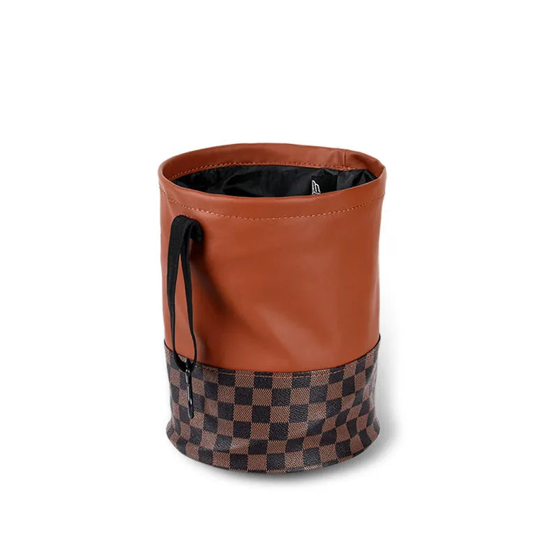 Brown leather folding interior trash can with a retractable handle, shown unfolded.