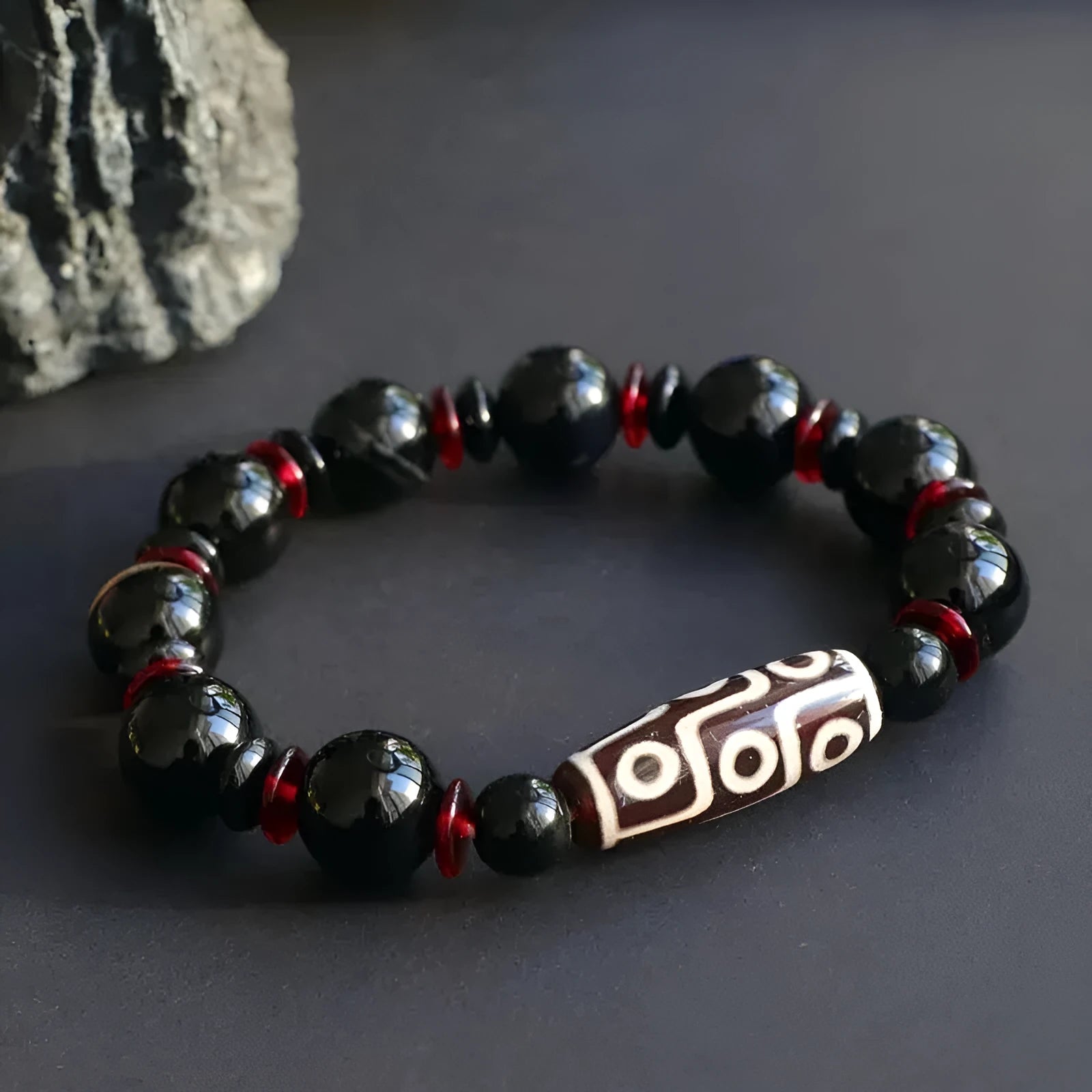 Hand-woven black agate dzi bead bracelet with 11mm geometry beads on a wrist.