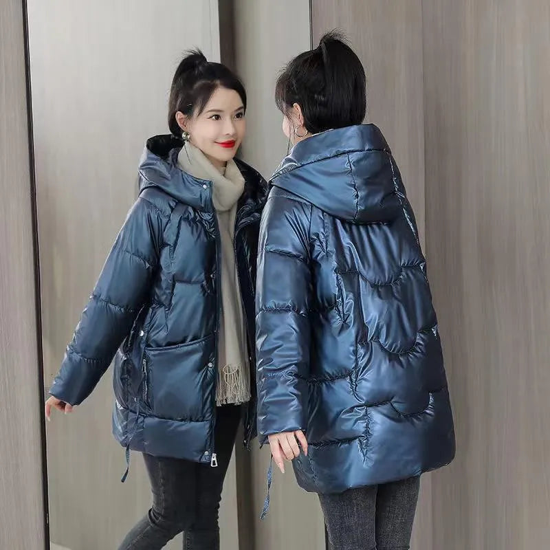 Green loose-fit hooded women's winter jacket on a hanger, showing long sleeves.