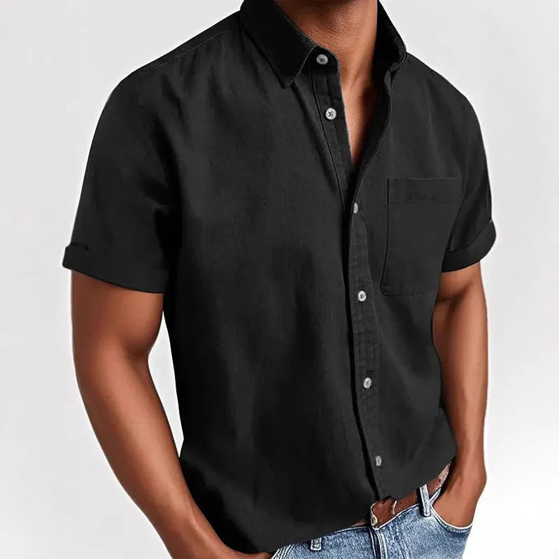 Man wearing a solid colour short-sleeved shirt with a polo collar and a single chest pocket.