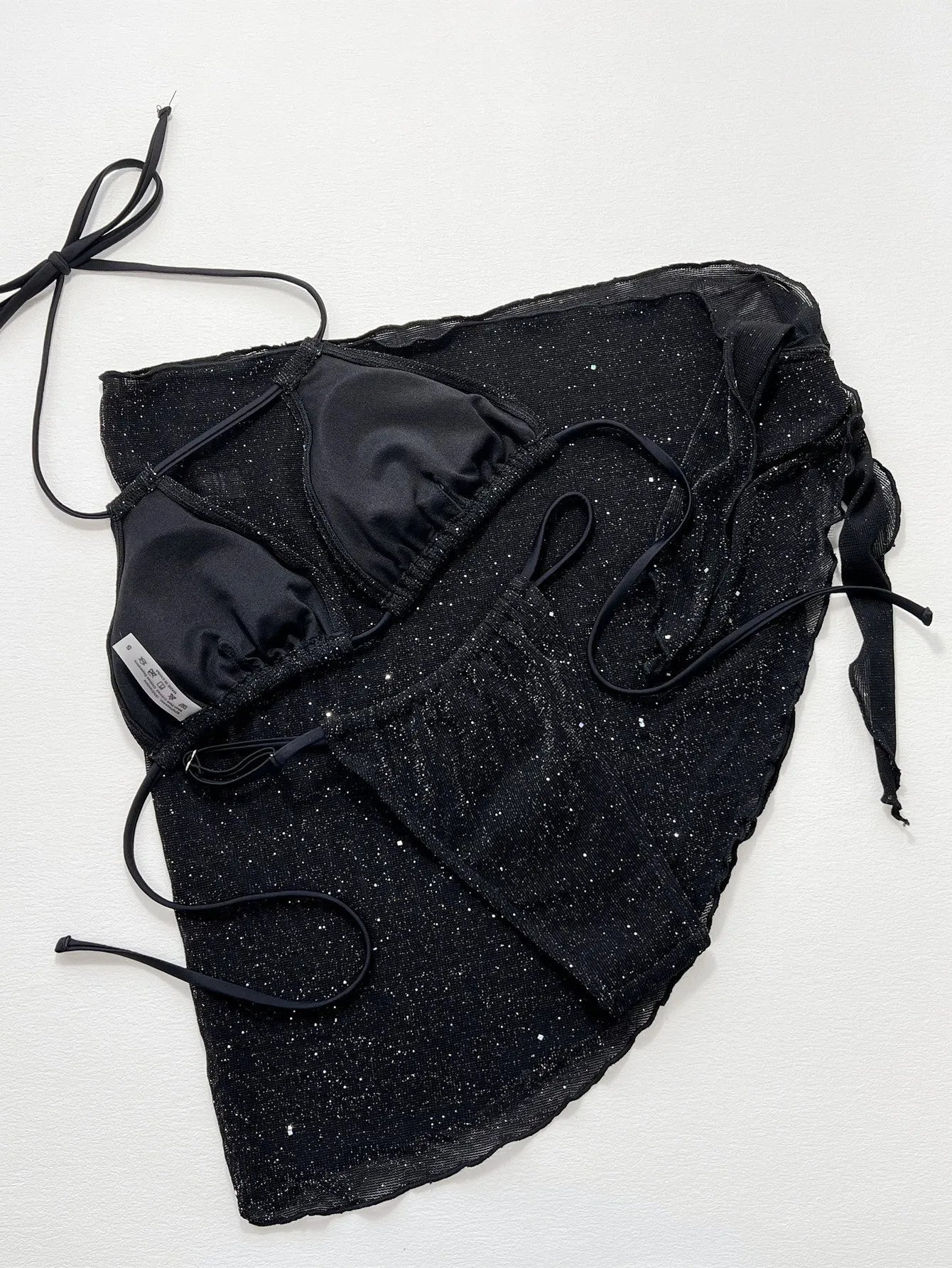 Black three-piece swimsuit bikini set with matching shorts on a mannequin