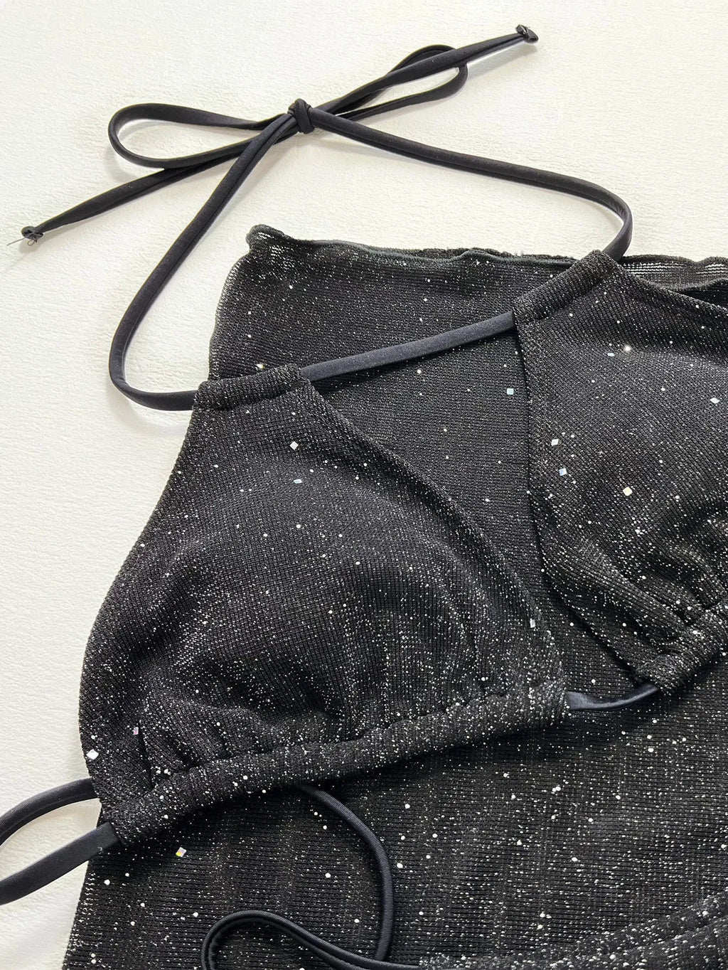 Black three-piece swimsuit bikini set with matching shorts on a mannequin